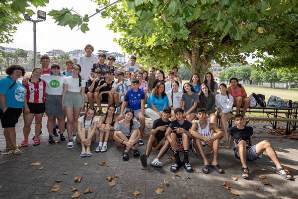 La consejera, Begoña Gómez del Río, junto a un grupo de jóvenes que estos días participan en un campamento en el Albergue de Loredo (Foto: Jose Cavia)