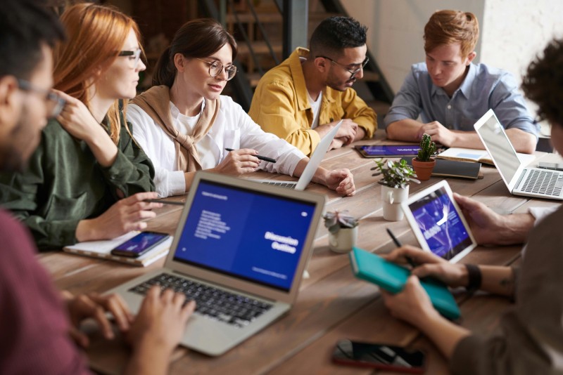 grupo de personas jóvenes alrededor de mesa de trabajo