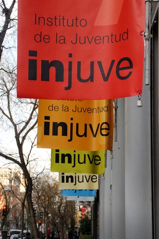 imagen de banderas de INJUUVE en fila en fachada con diferentes colores