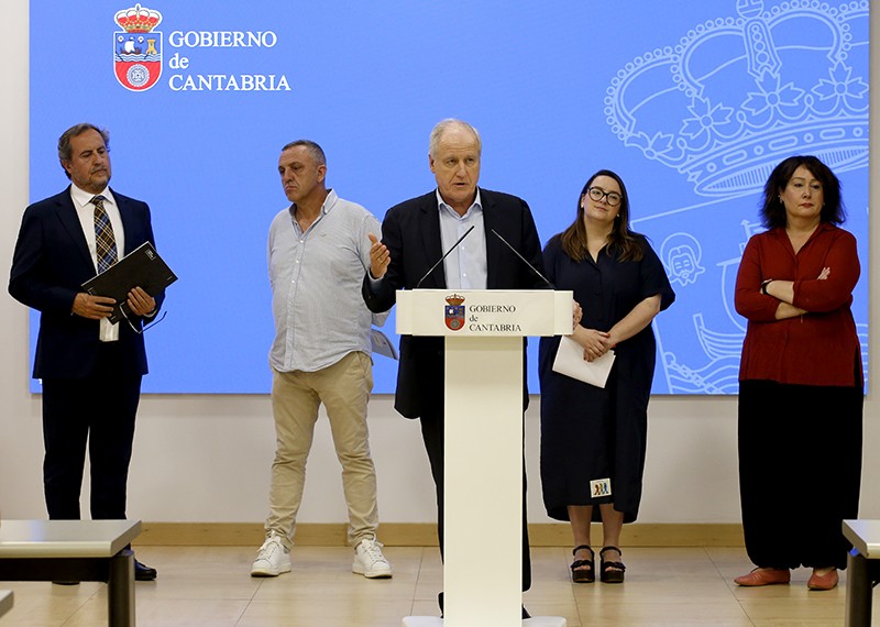 Eduardo Arasti, Consejero de Industria, Empleo, Innovaci&oacute;n y Comercio del Gobierno de Cantabria, en atril junto a su equipo alrededor