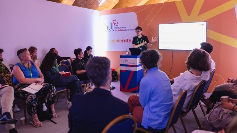 grupo de personas escuchando a ponente de la convención hablando desde atril