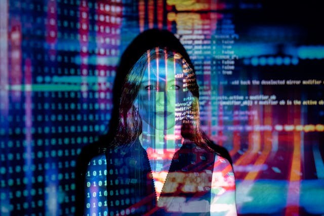 mujer de fondo tras proyección de código alfanumérico en diferentes colores
