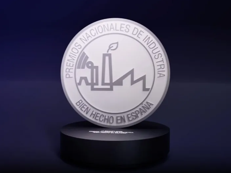 Sobre fondo negro, un medallón gris claro, en la parte superior; Premios Nacionales de Industria, en la inferior; Bien hecho en España. Centro; logo